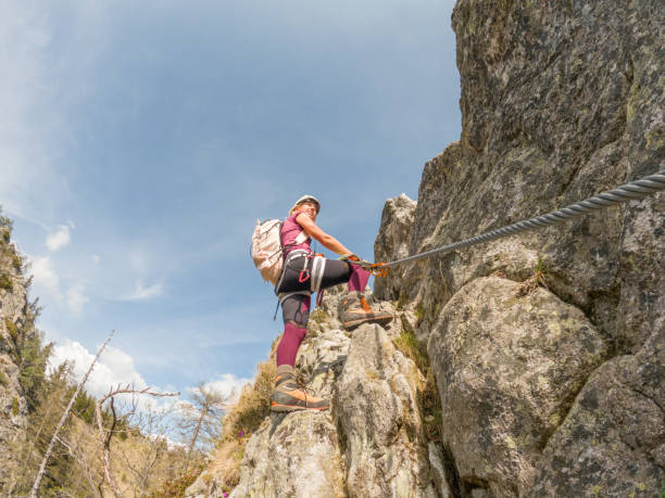 istock Woman rock climbing on Via Ferrata route 1396697882