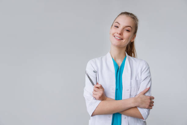 junge zahnärztin in uniform isoliert auf weiß - dentist stock-fotos und bilder