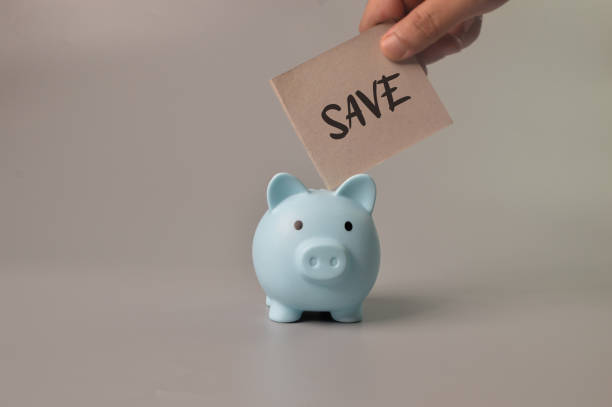 istock Man hand putting save note into piggy bank. Saving money concept. 1396702257