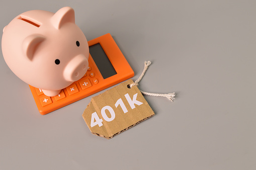 Piggy bank, calculator and label tag written with 401K
