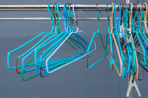 A group of the old hanger is arranged on the stainless steel bar of the clothesline. A group of the old hanger is arranged on the stainless steel bar of the clothesline, near the house wall, front view with the copy space. clothes hanger rod stock pictures, royalty-free photos & images