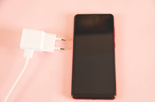 istock smart phone with usb on the pink desk 1396703950
