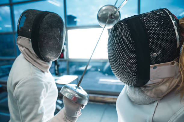 Close up of two professional sports women at the fencing duel