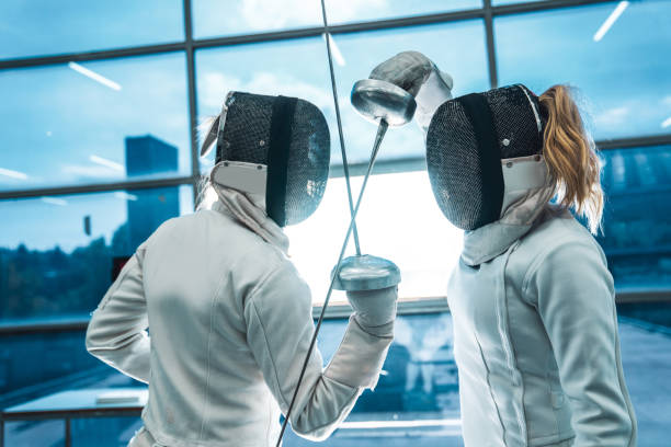 Close up of two professional sports women at the fencing duel