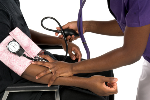 Close Up Detail of an African American nurse taking the blood preasure of a male African American patient