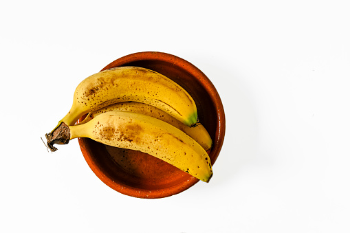 Canarian banana, yellow in a bowl, on a white background.