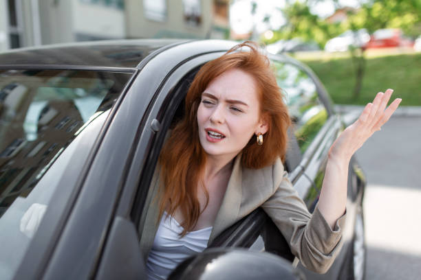 istock displeased woman looking out from side window and pointing with hand while driving car on blurred foreground 1396707231