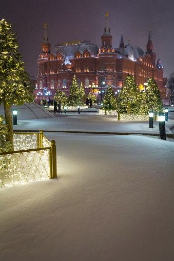 Selective focus on snow.Moscow Kremlin and Christmas trees on Red square. New Year decorations in Russia during snowfall