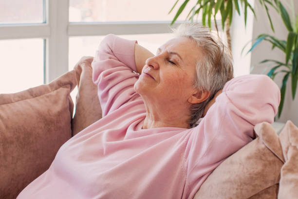 istock Relaxed satisfied older woman sitting leaning back on couch 1396712875