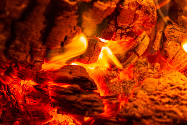 Glowing Hot Charcoal Briquettes Close-up Background Texture.Burning firewood in the fireplace close up. BBQ fire. Charcoal background. Charcoal fire with sparks.