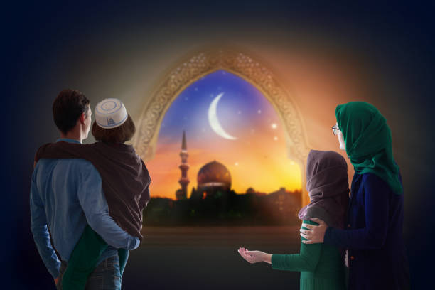 Ramadan Kareem greeting. Family looking at mosque. Ramadan Kareem greeting. Family at window looking at Islamic city with mosque skyline, crescent moon and stars. Muslim parents and children pray. Mother, father and kids celebrate end of fasting. hari raya family stock pictures, royalty-free photos & images
