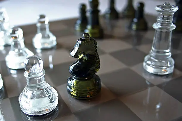 Queen chess piece lurking behind knight