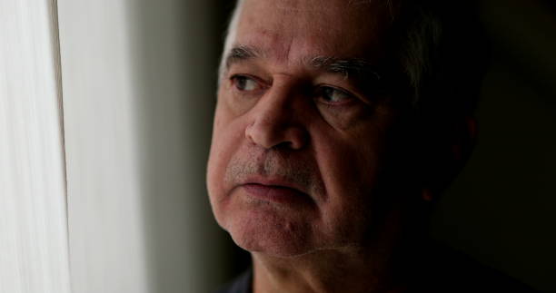 istock Contemplative older man standing by window thinking. Thoughtful sad depressed senior person 1396719003