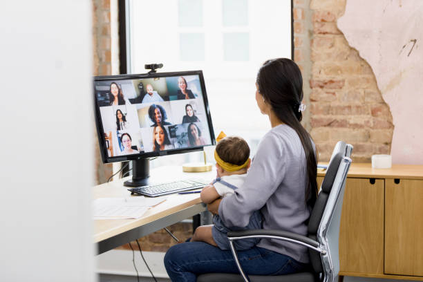 istock Mother holds baby while meeting with diverse co-workers via teleconferencing 1396721830