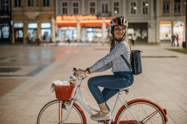 Young woman riding a bicycle in city at night.