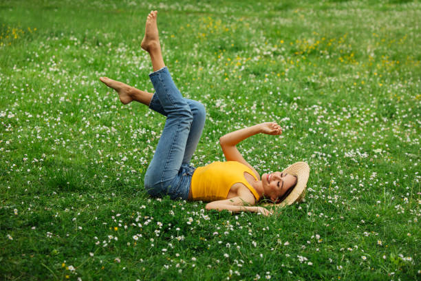 istock Smiling young woman lying on grass 1396724259