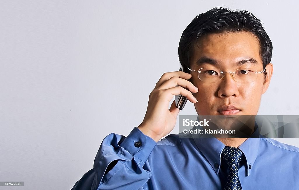 Uomo d'affari asiatici con telefono - Foto stock royalty-free di Abbigliamento da lavoro