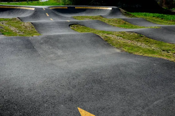 bike path in the car park Pumping (moving up and down) is used instead of pedaling and bouncing to move bicycles, scooters, skateboards and inline skates along the modular pumptrack track