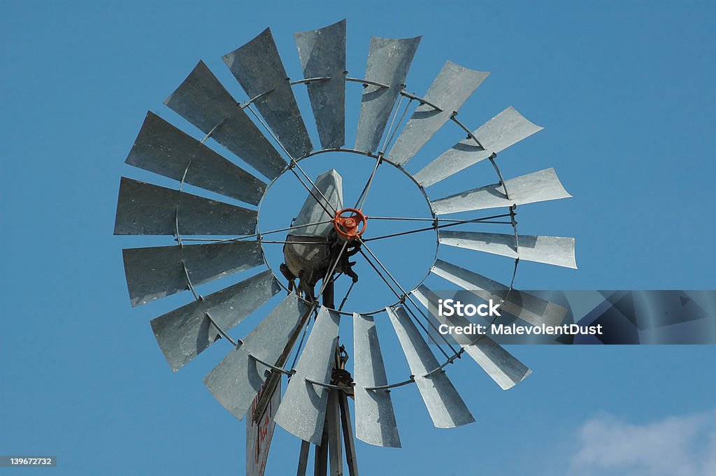 Windmill An old windmill sits idle against a blue sky full of wispy clouds. Antique Stock Photo