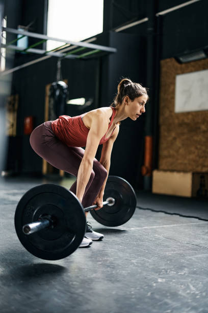 mulher musculosa fazendo musculação com sino em uma academia. - sports training muscular build women body care - fotografias e filmes do acervo