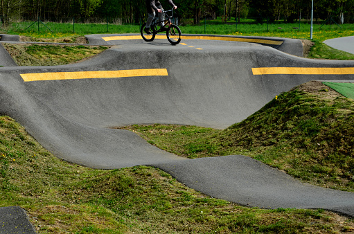 bike path in the car park Pumping (moving up and down) is used instead of pedaling and bouncing to move bicycles, scooters, skateboards and inline skates along the modular pumptrack track