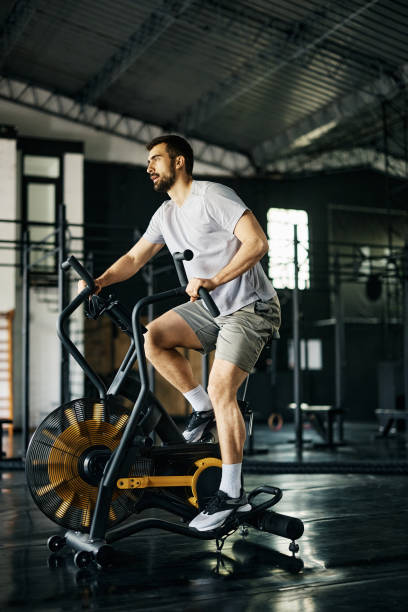 istock Male athlete having gym training on exercise bike. 1396729493
