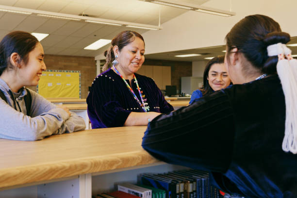 istock High School Teacher and Students in a School Library 1396729784