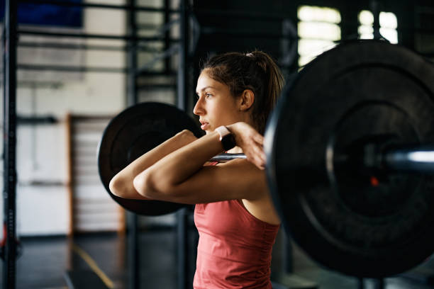 istock Athletic woman having strength training with a barbell while working out in gym. 1396729848