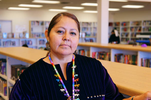 istock High School Teacher in a Library 1396729926