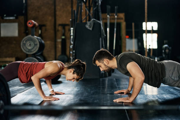 istock Athletic couple doing push-ups while having sports training in a gym. 1396730810