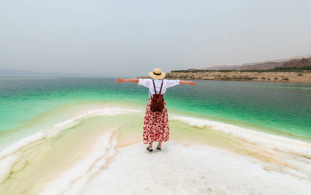 The girl with hat on the shore  of the Dead Sea at sunrise The girl with hat on the shore  of the Dead Sea at sunrise dead sea scrolls stock pictures, royalty-free photos & images