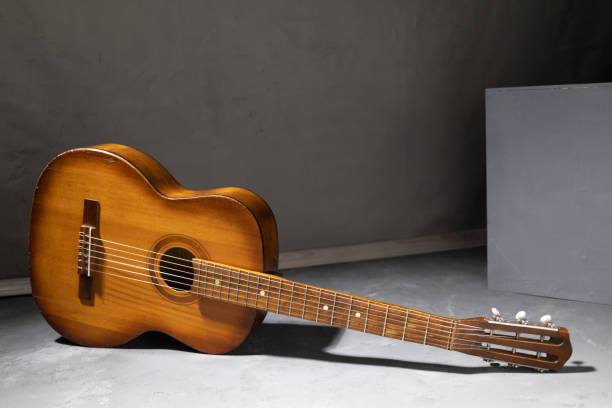 Acoustic guitar at floor. Music concept in studio with classic guitar near wall