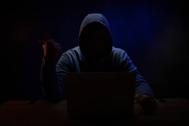 istock Hacker near front of computer laptop. Man hacker in dark room 1396733338