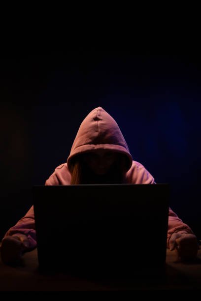 istock Hacker near front of computer laptop. Woman hacker in dark room 1396733344