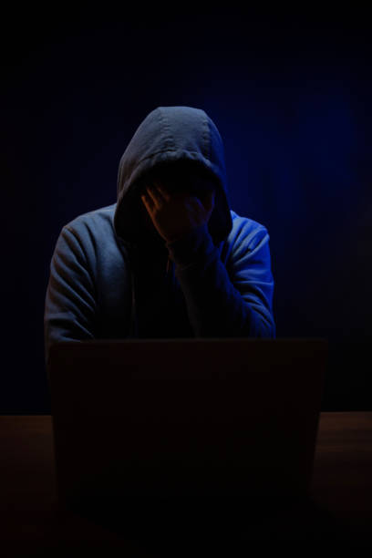 istock Hacker near front of computer laptop. Man hacker in dark room 1396733360