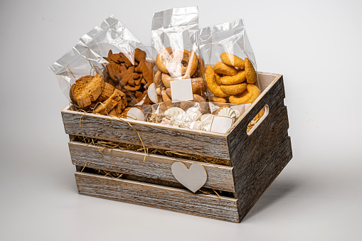 wooden box with straw and a set of different cookies, isolated, copy space, close-up