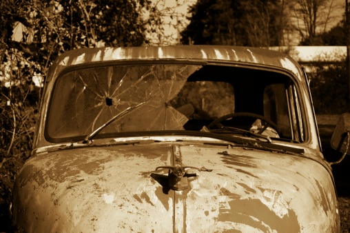 An abandoned vehicle Bonnie and Clyde style. Shallow depth of field, focus on the hood ornament.