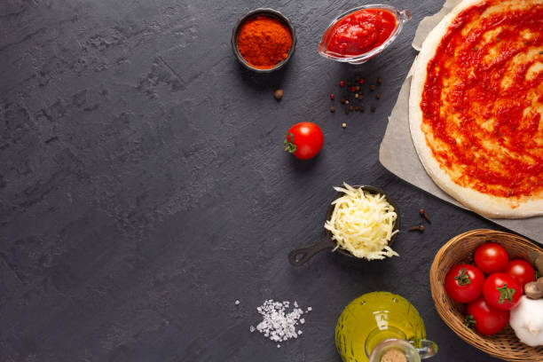 istock Pizza and sauce homemade cooking with ingredients on table. Dough pizza at tabletop 1396735231