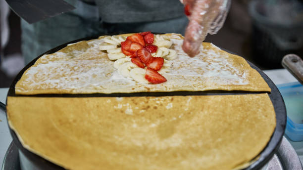 istock Making delicious crepes on a grill with fruit and chocolate 1396736207