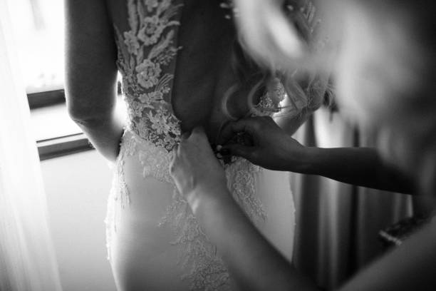 istock Bridesmaids helping bride getting dressed for the wedding ceremony. 1396736758
