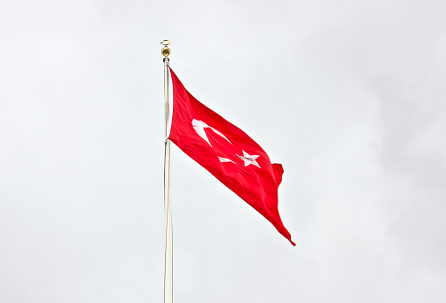 Kyrgyzstan flag on the mast on deep blue sky background. Kyrgyz republic national flag