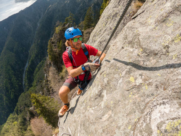 istock Man climbing steep via ferrata on rock cliff 1396741702