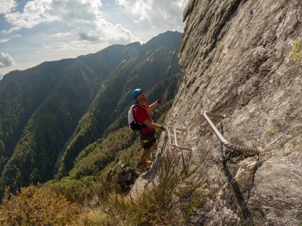 istock Young man climbs via ferrata rock face 1396741797