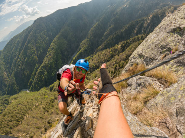 istock POV down arm to young man climbing up a rock face 1396741836