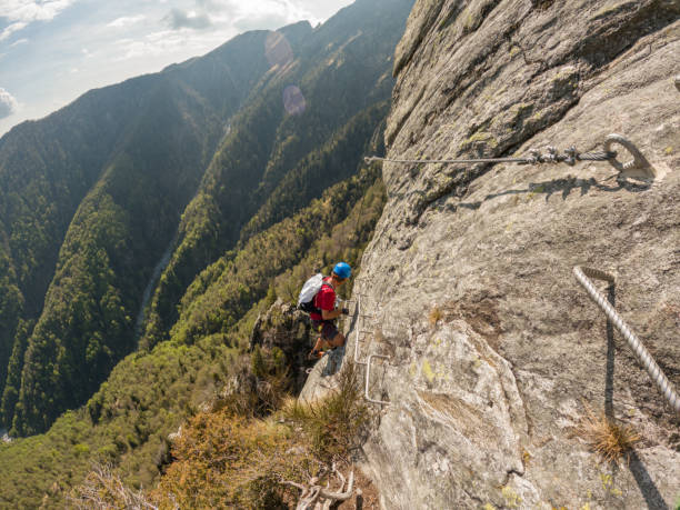 istock Young man climbs via ferrata rock face 1396741973
