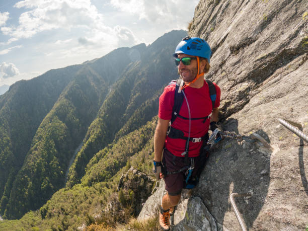 istock Man climbing steep via ferrata on rock cliff 1396742742
