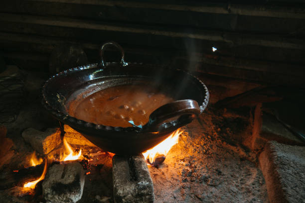 istock Mexican indigenous woman preparing Mole on a clay pot 1396742979