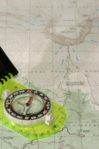 An orienteering compass shows the way to the summit on a topographic map of Mt. St. Helens in Washington State.