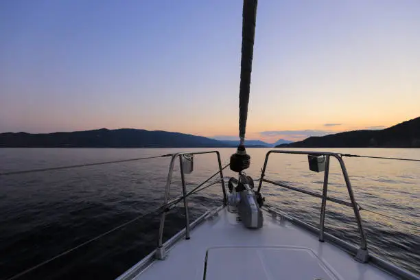 Bow of sailing yacht, view from the sailboat at sunset in Greece