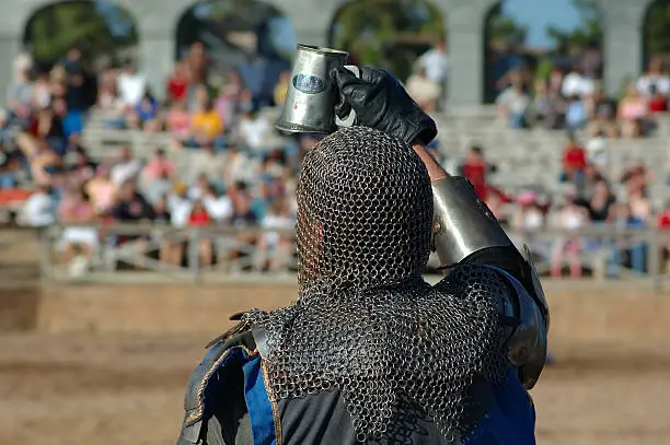 A knight toasts the crowd before he prepares for a joust.